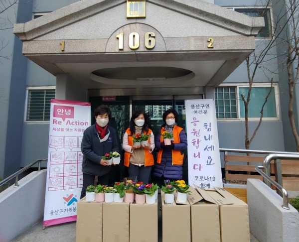 25일 용산구자원봉사센터 소속 봉사자들이 지역 내 공동주택을 찾아 꽃화분을 전달했다